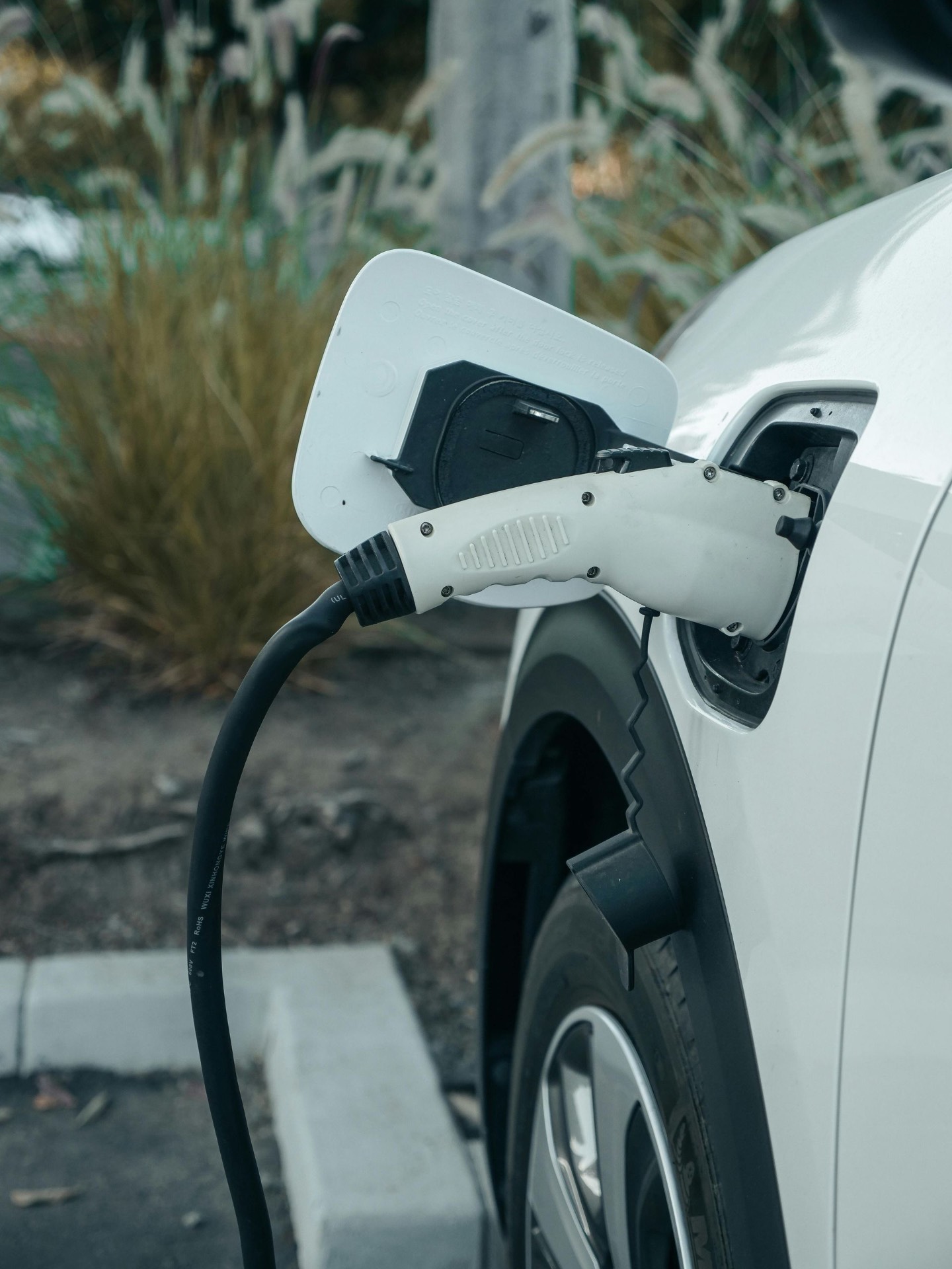 EV charging cable plugged into a white electric vehicle