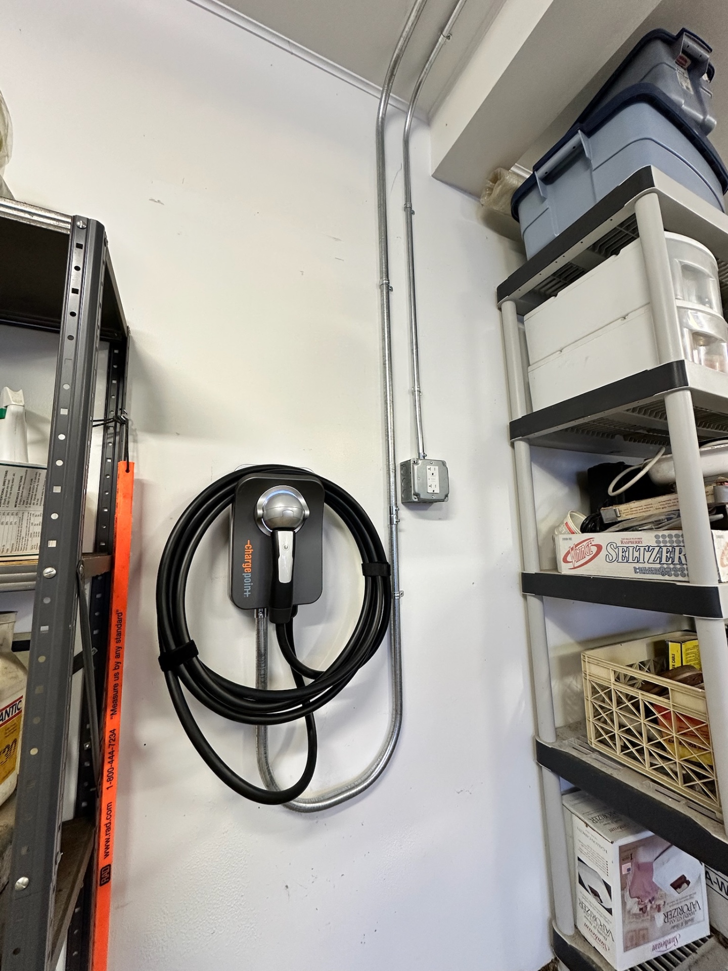 ChargePoint Home Flex EV charger installed in a storage room with rigid metal conduit running up to the ceiling