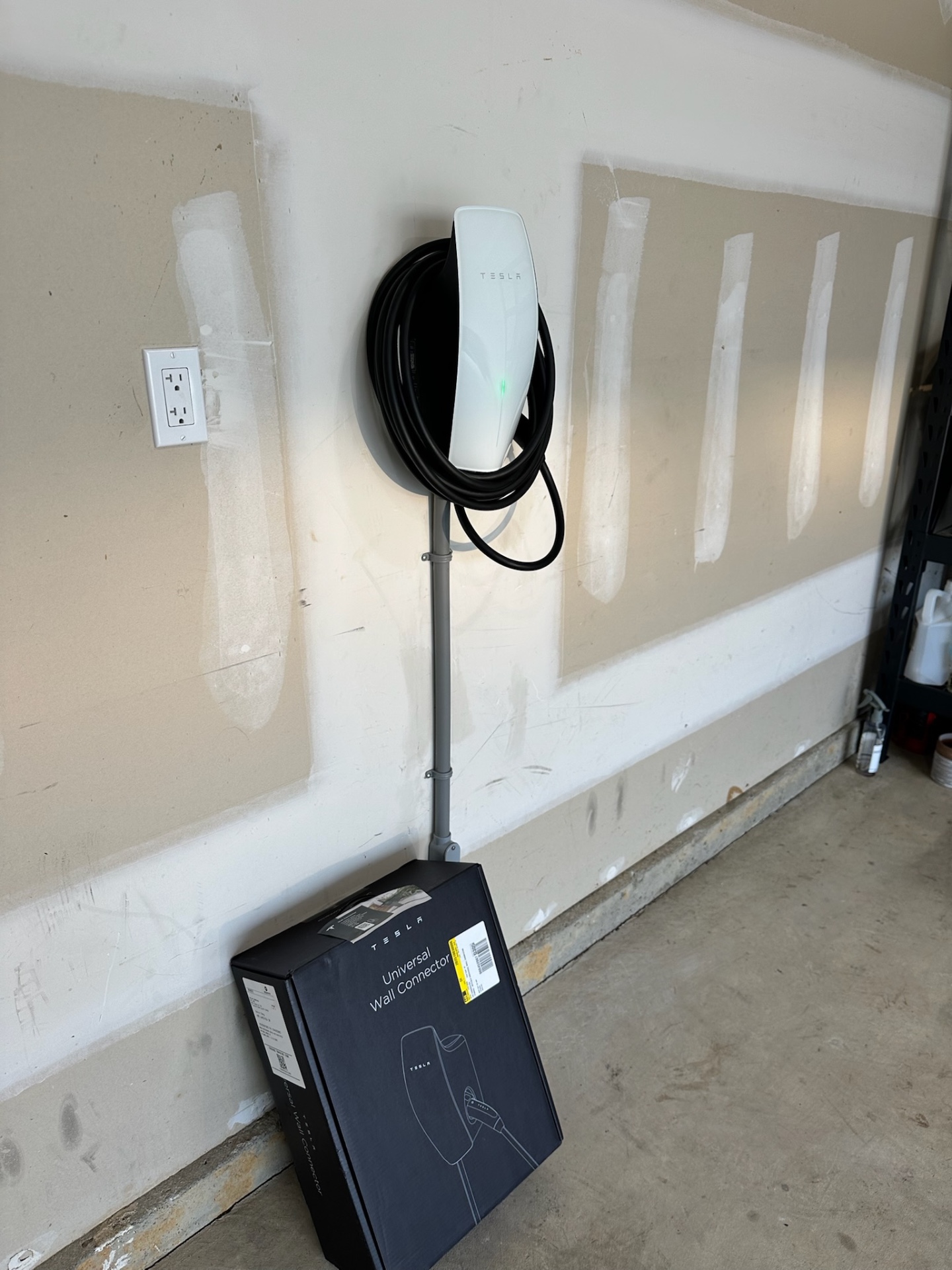 Tesla Universal Wall Connector freshly mounted in a Chester County garage with conduit run to the panel